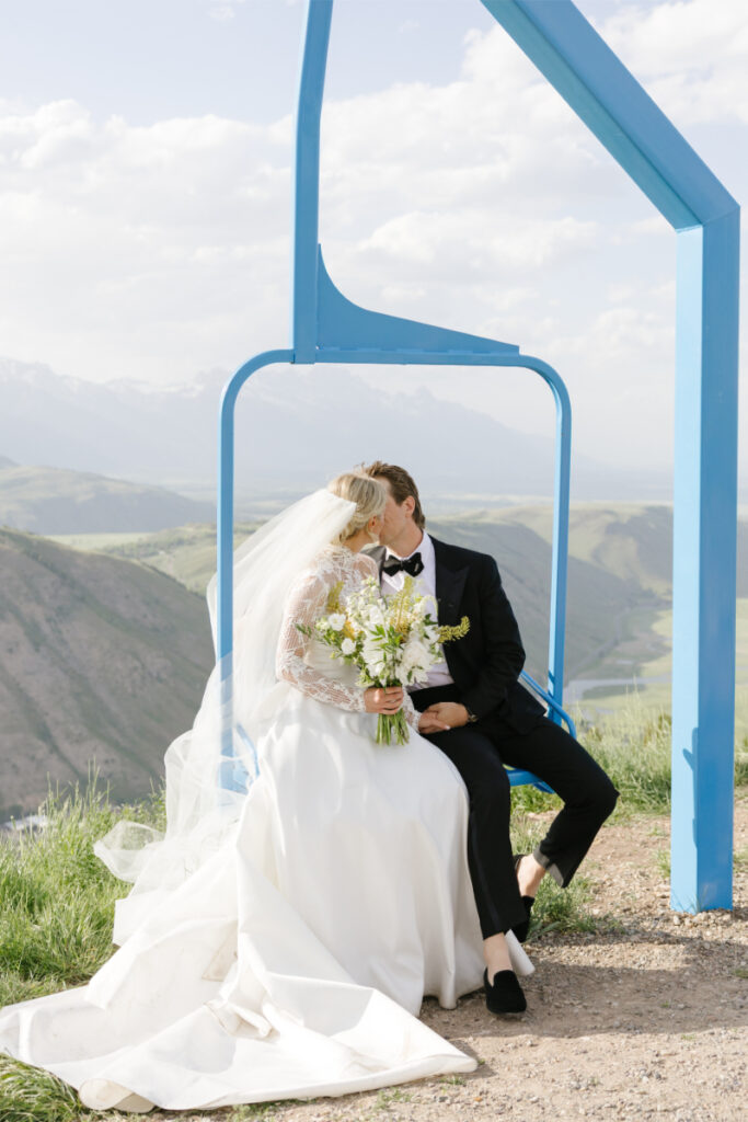 Bride and groom kissing on a mountain chairlift during their Jackson wedding celebration.