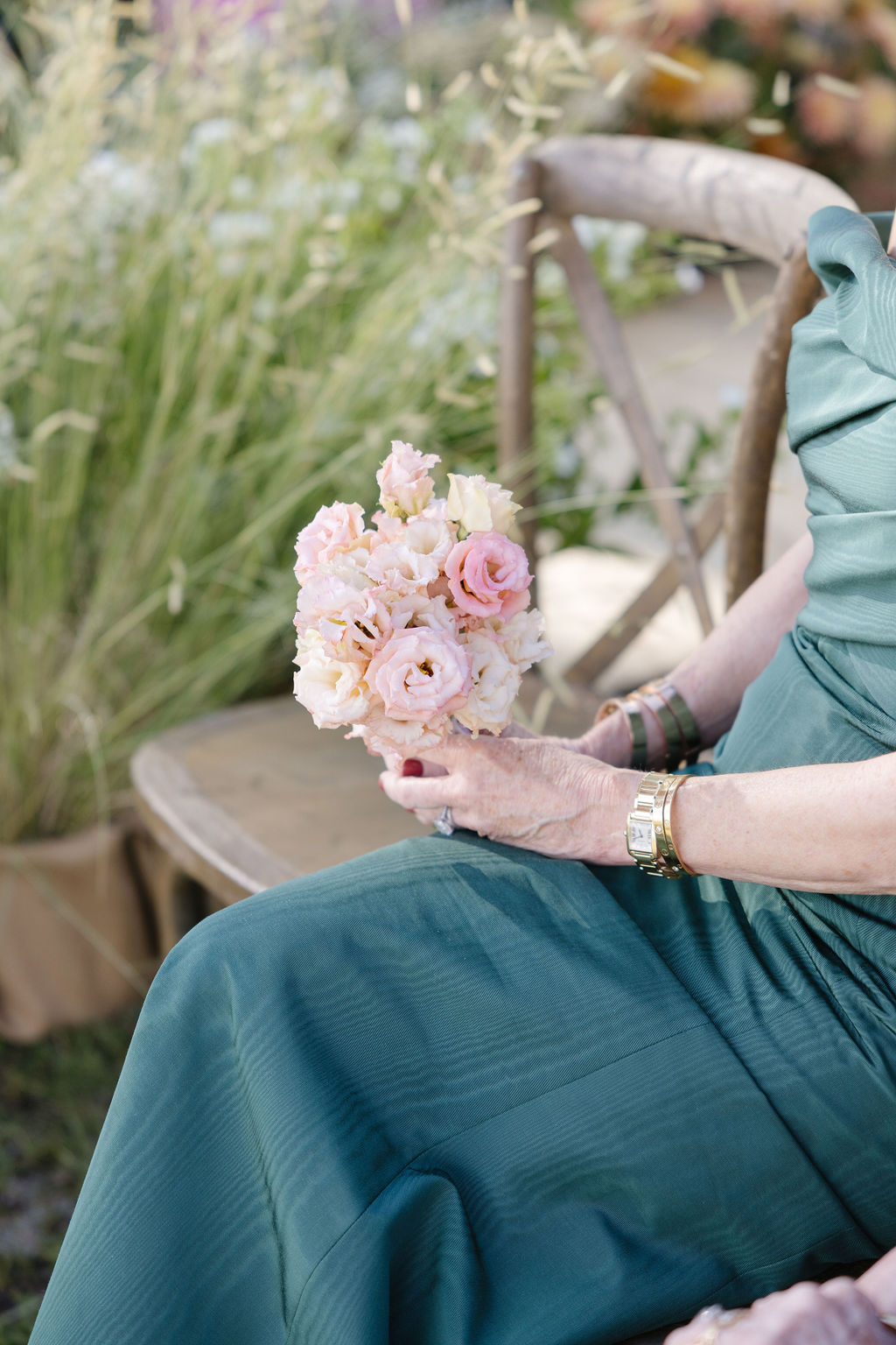 Wedding guest holding a pink floral bouquet during an outdoor Jackson Hole celebration