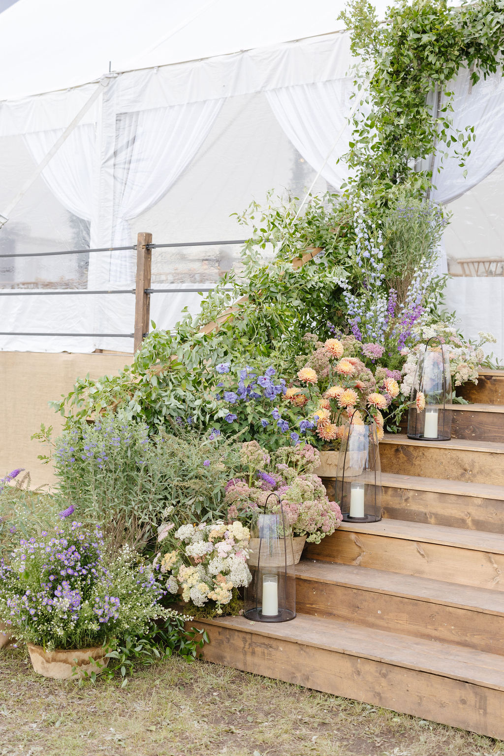 Colorful floral arrangements and lanterns decorating a tented Jackson Hole wedding reception