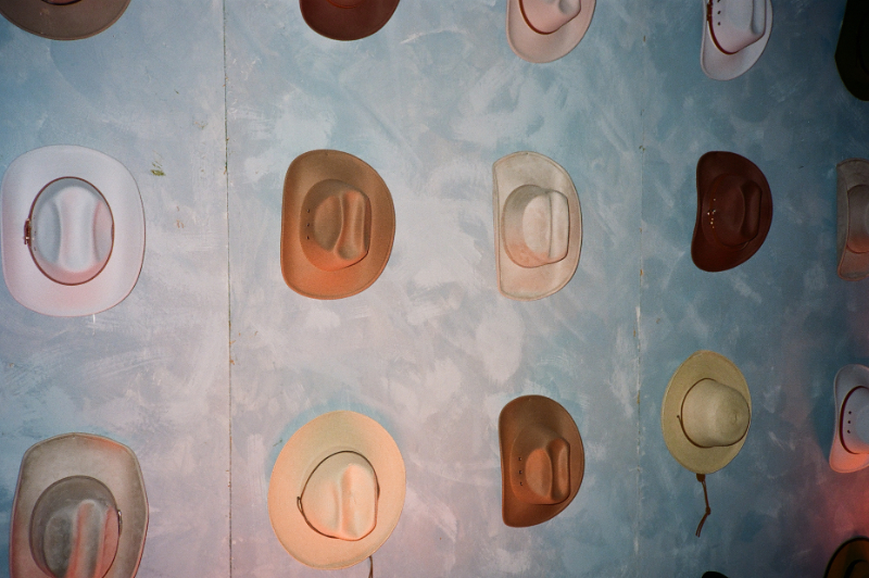 Dusty blue wall with cowboy hats displayed for a Jackson Hole wedding.